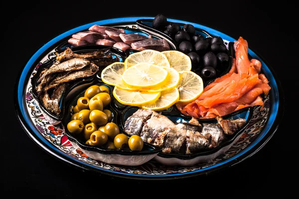 Assorted fish on a plate on a dark background. — Stock Photo, Image