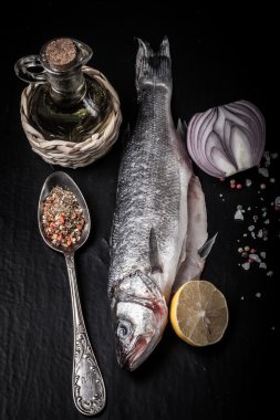 Taze deniz balığı koyu arka plan üzerinde baharatlarla yalan. renkli