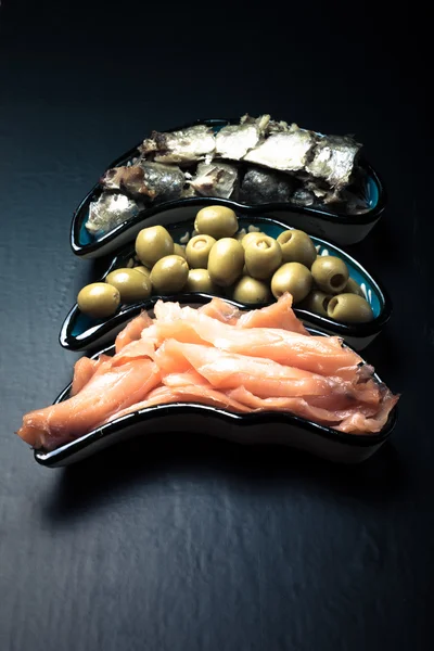 Рыбный ассортимент и оливки на тарелке на темном фоне. С — стоковое фото