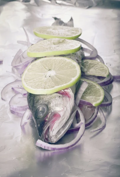 Peixe preparado para assar na folha com limão e cebola. — Fotografia de Stock