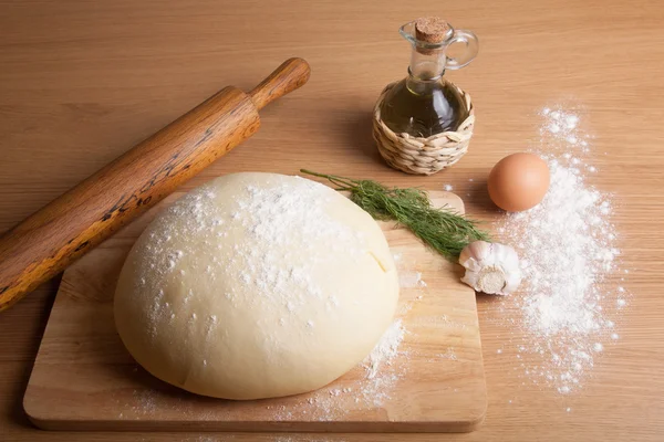 Pasta su una tavola con farina. olio d'oliva, uova, mattarello, garli — Foto Stock