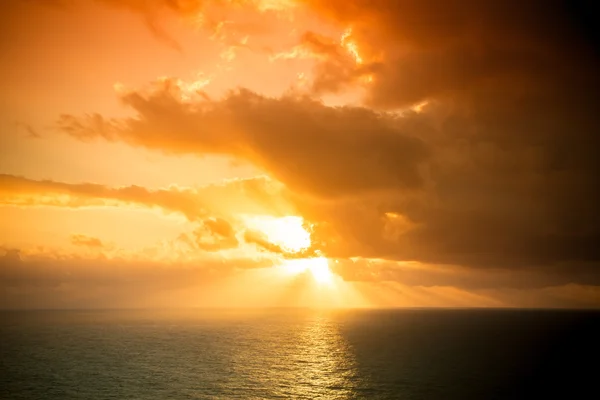 海の上の暗い曇天で劇的な夕日の光線。T — ストック写真