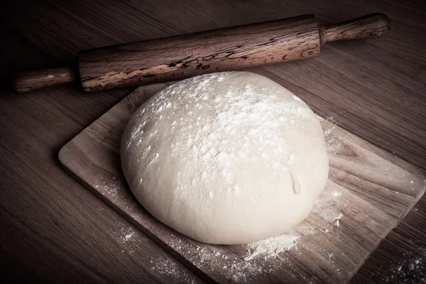 Pâte avec rouleau à pâtisserie sur table en bois.Teinté — Photo