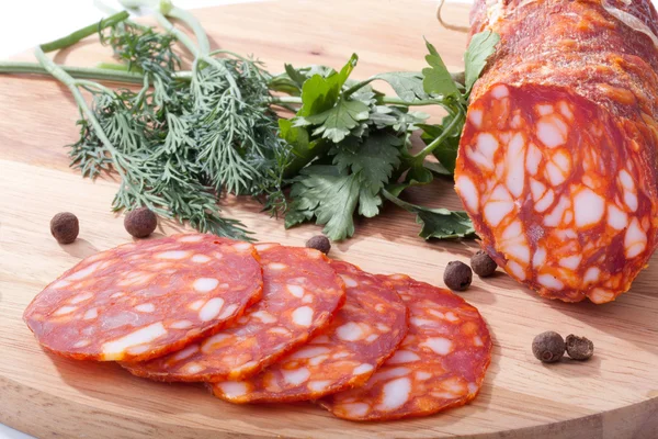 Chorizo sausage with herbs and pepper on the board — Stock Photo, Image