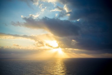 Bir bulutlu karanlık gökyüzü okyanus üzerinden dramatik günbatımı ışınları. T