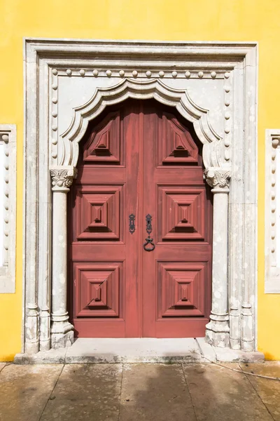 Porta de madeira velha emoldurada por uma pedra esculpida . — Fotografia de Stock