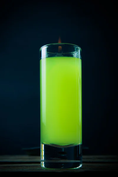 Glass with a drink by the fire on a black background — Stock Photo, Image
