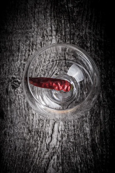 Pimientos rojos picantes en un vaso sobre un fondo de madera oscura —  Fotos de Stock