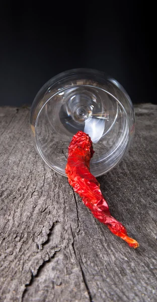 Pimientos rojos picantes en un vaso sobre un fondo de madera oscura —  Fotos de Stock