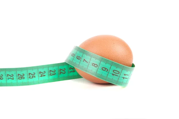 Measurement tape wrap around egg, symbolize of healthy eating of — Stock Photo, Image