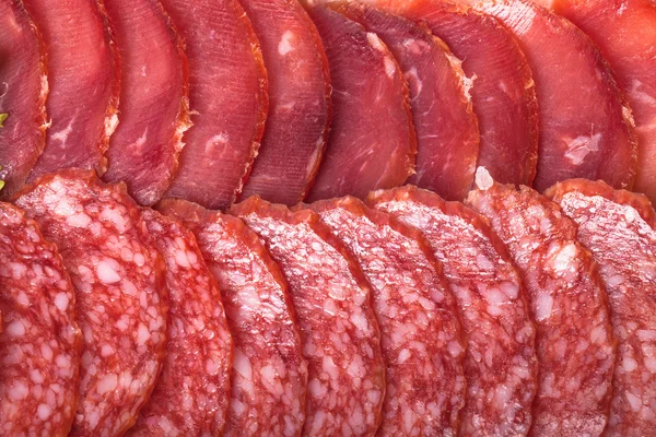 El fondo - el detalle del salami en rodajas —  Fotos de Stock