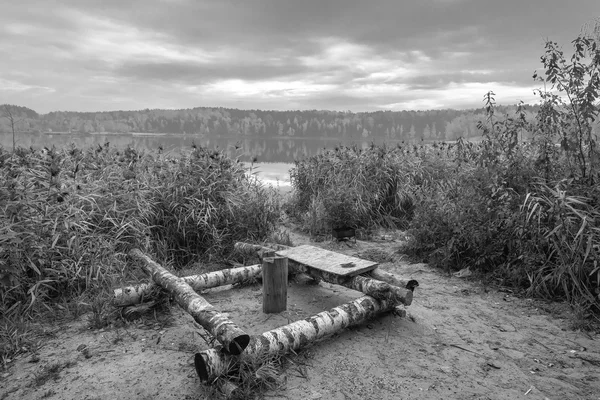 Resting place on the lake made of birch logs. Black and white — Stock Photo, Image