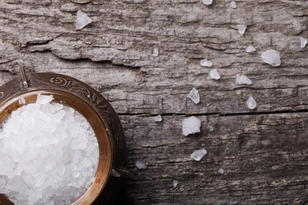 Sea salt in an old utensils on wooden table — Stock Photo, Image