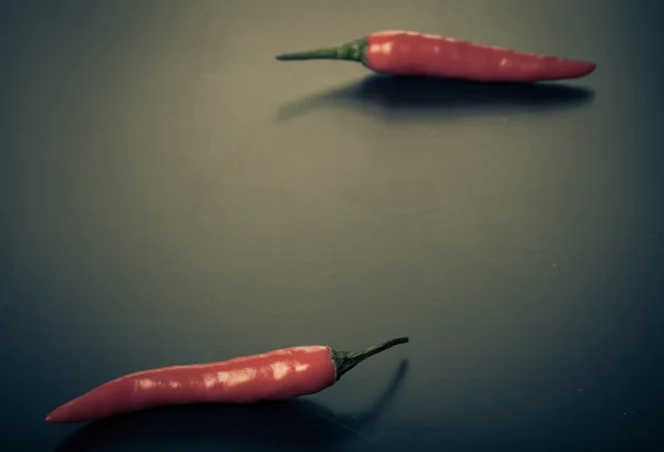 Δύο κόκκινες πιπεριές τσίλι σε σκούρο φόντο — Φωτογραφία Αρχείου