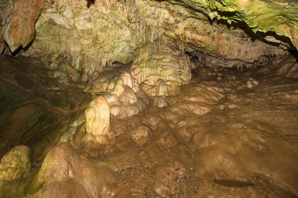 Muur van de grot bedekt geologische formaties. getint — Stockfoto