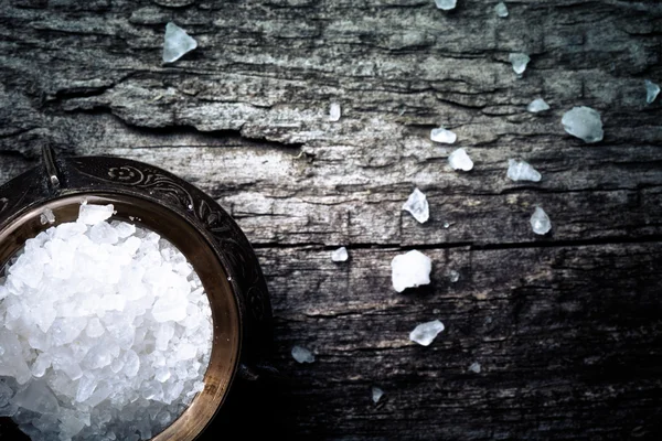 Sea salt in an old utensils on wooden table — Stock Photo, Image