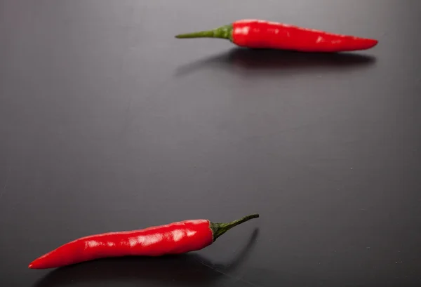 Δύο κόκκινες πιπεριές τσίλι σε σκούρο φόντο — Φωτογραφία Αρχείου
