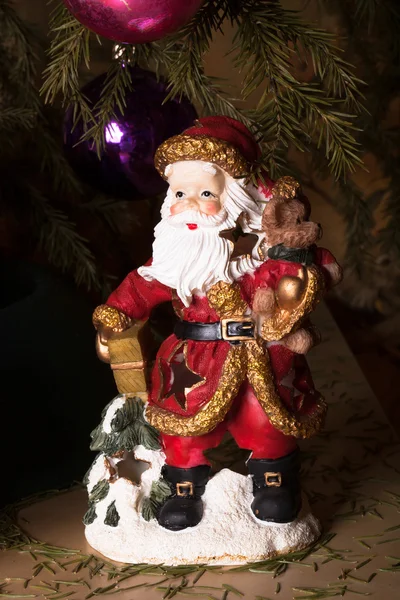 Papai Noel cerâmico sob a árvore de Natal — Fotografia de Stock