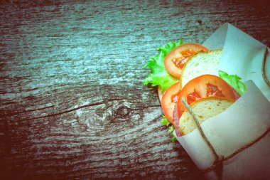 dokulu bir ahşap tahta üzerinde sandviç sargılı sicim. tinted.Old f
