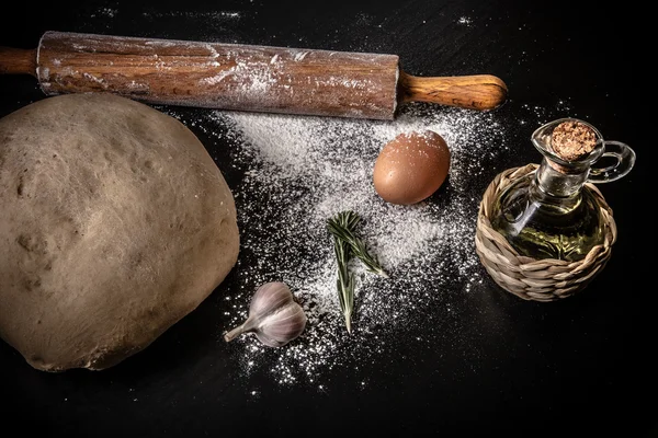 Teig auf einem Brett mit Mehl. Olivenöl, Eier, Nudelholz, Garli — Stockfoto