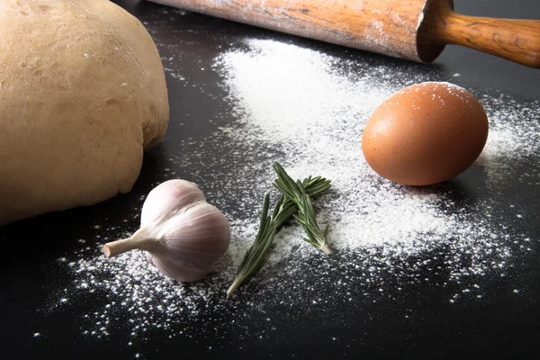 Farina, mattarello, uovo, rosmarino, aglio e pasta per torta — Foto Stock