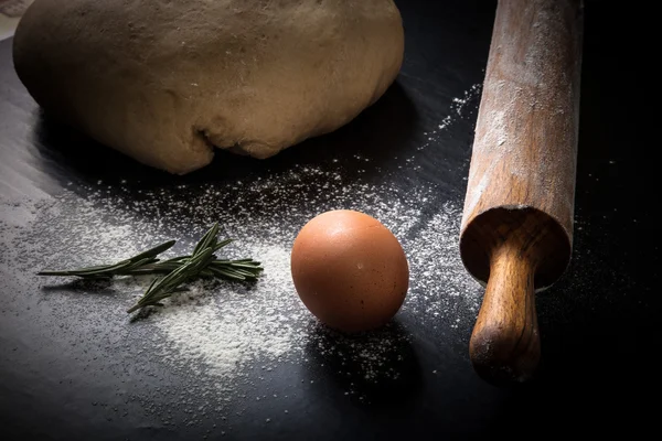 Flour, rolling pin, egg, rosemarin and dough for pie. Toned — Stock Photo, Image
