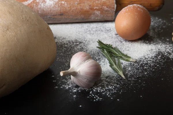 Flour, rolling pin, egg, rosemary, garlic and dough for pie. Ton — Stock Photo, Image