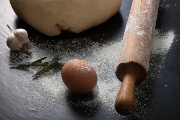 Flour, rolling pin, egg, rosemary, garlic and dough for pie. Ton — Stock Photo, Image