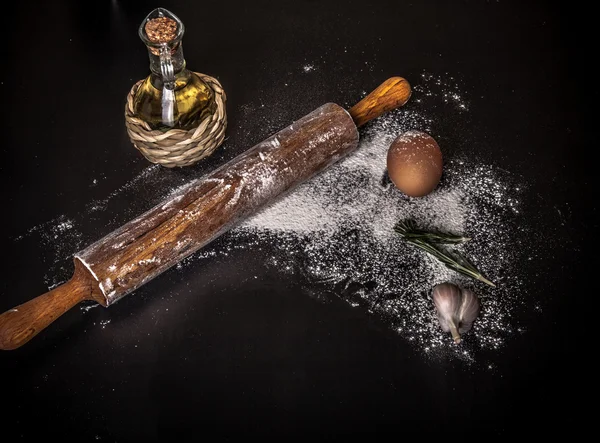 Dough on a board with flour. olive oil, eggs, rolling pin, garli — Stock Photo, Image