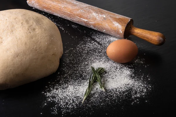 Flour, rolling pin, egg, rosemary and dough for pie — Stock Photo, Image