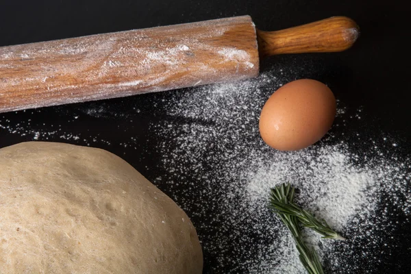 Flour, rolling pin, egg, rosemarin and dough for pie — Stock Photo, Image