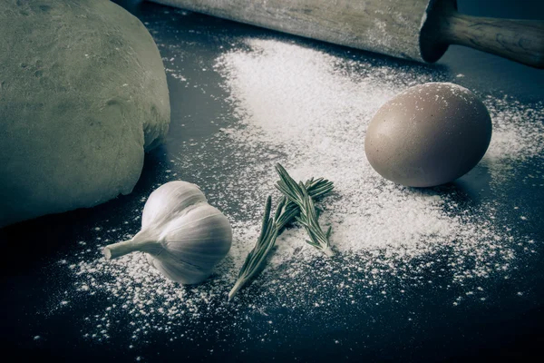 Flour, rolling pin, egg, rosemary, garlic and dough for pie. Ton — Stock Photo, Image