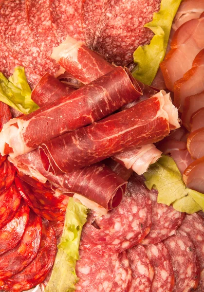 Slices of different kinds of meat with green salad. Toned — Stock Photo, Image