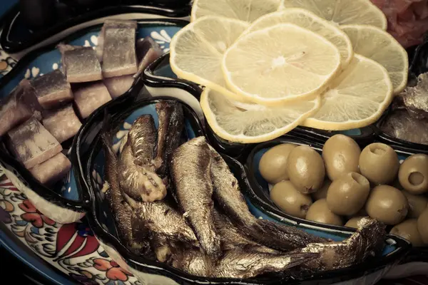 Assortimento di pesce, olive, fette di limone su piatto orientale. Tonica — Foto Stock