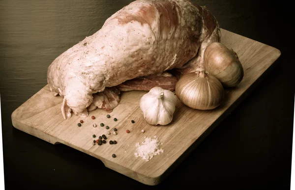 Carne crua, cebola, alho e temperos em uma tábua de madeira. Tonificado — Fotografia de Stock