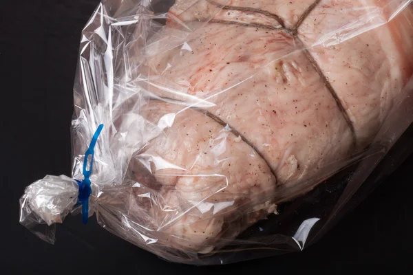 Rohes Fleisch mit Seil in der Verpackung auf schwarzem Hintergrund — Stockfoto