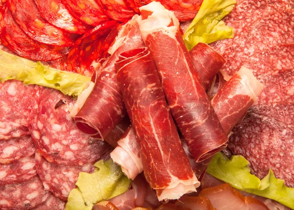 Slices of different kinds of meat with green salad. Toned — Stock Photo, Image