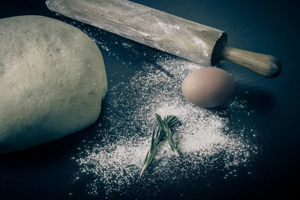 Flour, rolling pin, egg, rosemarin and dough for pie — Stock Photo, Image