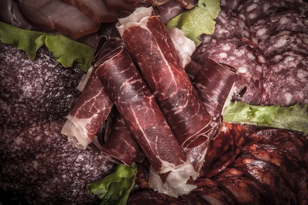 Segmenten van verschillende soorten vlees met groene salade. Afgezwakt — Stockfoto