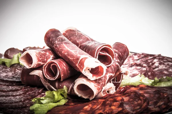 Slices of different kinds of meat with green salad. Toned — Stock Photo, Image