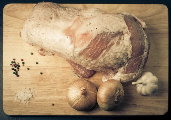 Carne cruda, cebolla, ajo y especias en una tabla de madera. Tonificado —  Fotos de Stock