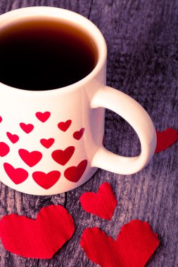Sevgililer günü kalpleri ve eski ahşap tabloda çay. Tonda