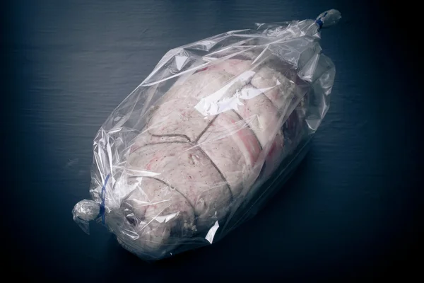 Nyers hús kötelet a csomagban, a fekete háttér. Tónusú — Stock Fotó