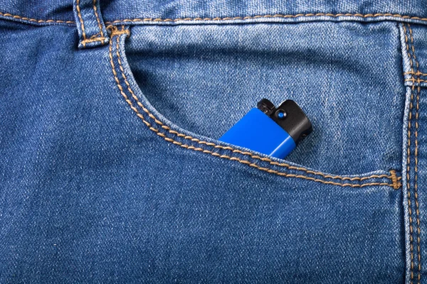 De zak van jeans met lichter. Doek achtergrond — Stockfoto