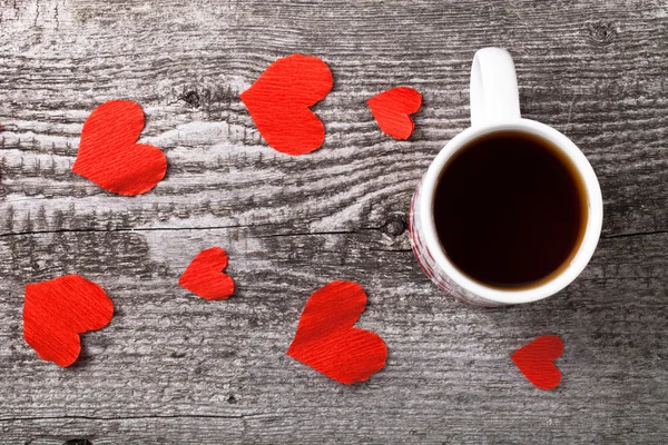 バレンタインの心と古い木製のテーブルに紅茶のカップ — ストック写真