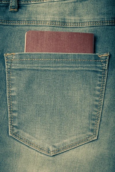 The pocket of jeans with document. Cloth background. Toned — Stock Photo, Image