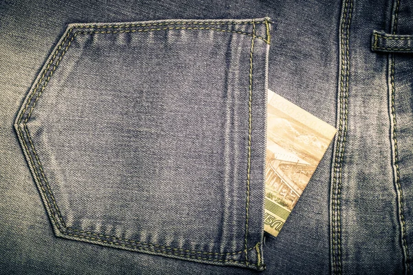 The pocket of jeans with money. Cloth background. Toned — Stock Photo, Image