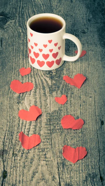 Valentine harten en kopje thee op de oude houten tafel. Afgezwakt — Stockfoto