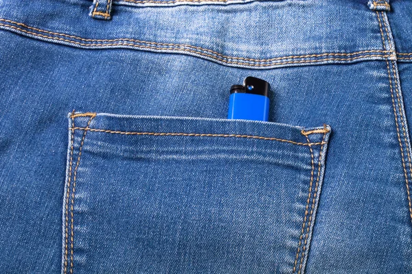 De zak van jeans met lichter. Doek achtergrond — Stockfoto