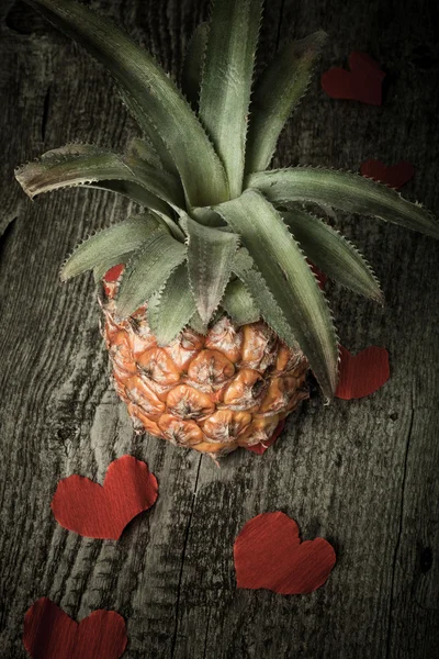 Muchos corazones de San Valentín con ananas en la vieja mesa de madera. Tonificado —  Fotos de Stock